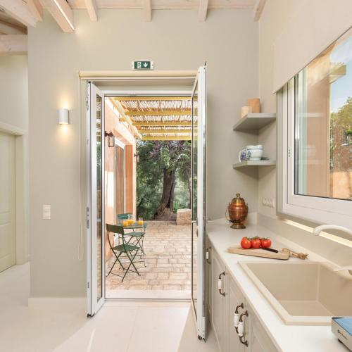 a kitchen with a door leading to a patio at Corfu OliveStone Village with Swimming pool in Ágios Márkos