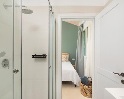 a bathroom with a glass door leading to a bedroom at The OliveStone Village - Yoga Retreat Paradise in Ágios Márkos
