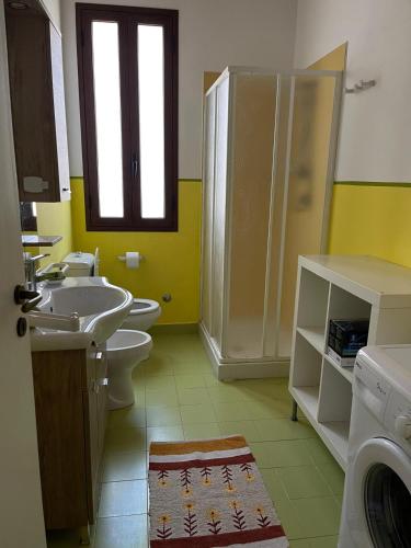 a bathroom with two toilets and a shower and a sink at Punta del Cane in Fontane Bianche