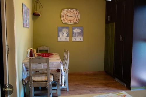 a dining room with a table and a clock on the wall at Luxury House with huge garden - Near "Mavra Volia" Beach in Emporeiós