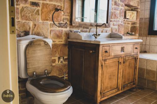 a stone bathroom with a toilet and a sink at Luxury House with huge garden - Near "Mavra Volia" Beach in Emporeiós
