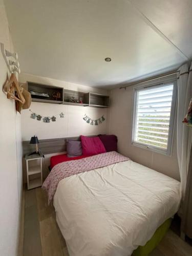 une petite chambre avec un lit et une fenêtre dans l'établissement Logement camping Nava Biscarrosse, à Biscarrosse