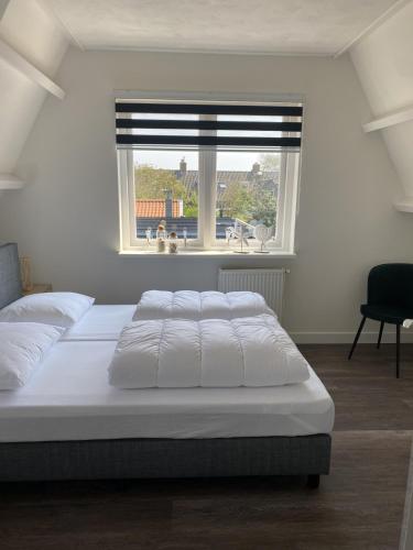 a bedroom with a large bed and a window at Beach Dream 3C in Petten