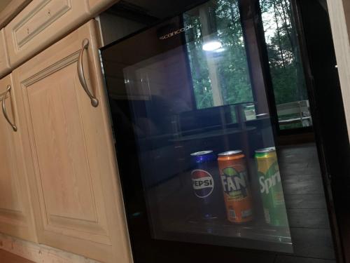 a microwave oven with several cans of soda at Sea House in Saulkrasti
