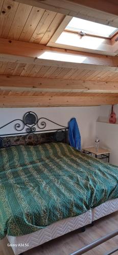 a bed in a room with a wooden ceiling at L'antica Torre a Mare in Lascari