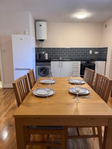 a wooden table with plates and wine glasses on it at Guest House in London in Isleworth