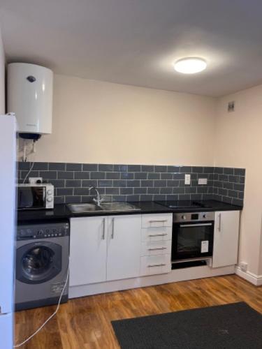 a kitchen with a sink and a dishwasher at Guest House in London in Isleworth