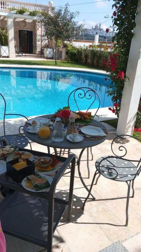 a table with food on it next to a swimming pool at Villa Caramia in Locorotondo