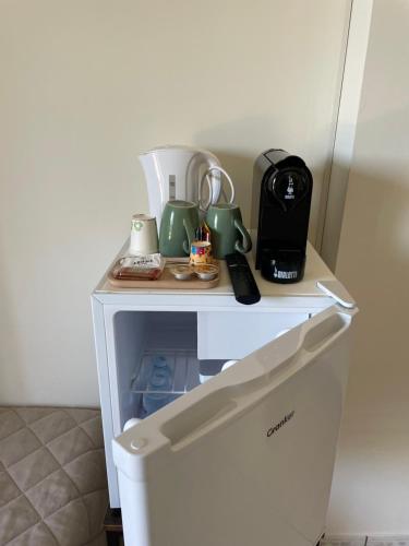 einen kleinen weißen Tisch mit Geräten auf dem Kühlschrank in der Unterkunft Arra Camere Sirolo - Rooms & Suite in Sirolo