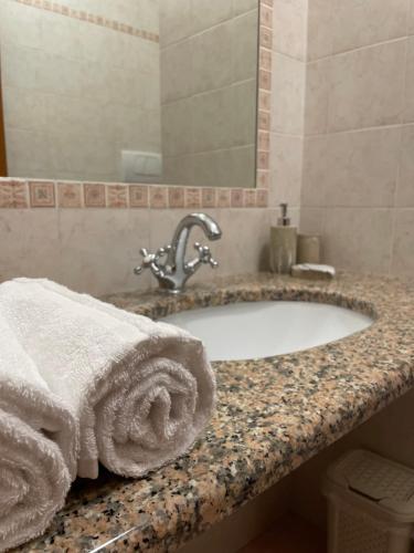 ein Bad mit einem Waschbecken und Handtüchern darauf in der Unterkunft Arra Camere Sirolo - Rooms & Suite in Sirolo