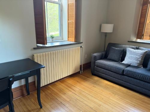 a living room with a couch and a table at Auberge de l'Abbaye d'Oka in Oka