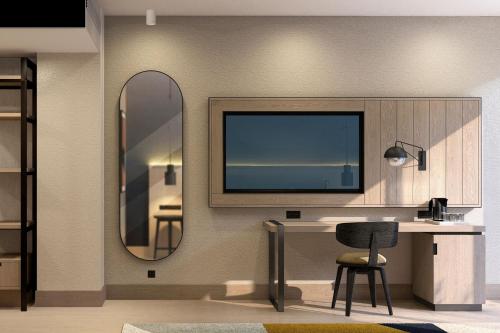 ein Wohnzimmer mit einem Schreibtisch und einem Spiegel in der Unterkunft Four Points by Sheraton Sunny Beach in Sonnenstrand