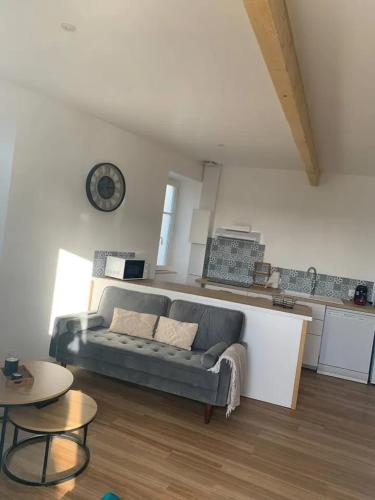 un salon avec un canapé et une table dans l'établissement Maison confortable proche de Barbezieux - 50 m² avec jardin partagé, à Barbezieux-Saint-Hilaire