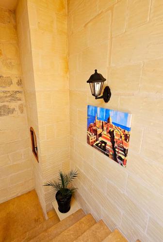 a wall with a picture and a lamp on a wall at Traditional Farmhouse Central Gozo in Xagħra