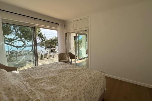 une chambre avec un lit et une vue sur un balcon dans l'établissement Cap d Antibes Villa contemporaine pied dans l eau, à Antibes