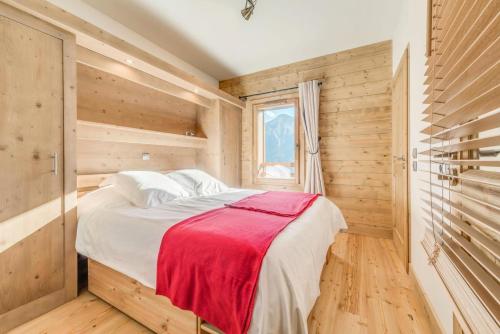 - une chambre avec des murs en bois et un lit avec une couverture rouge dans l'établissement Résidence Les Balcons EtoilÉs - Appartement 4 au pied des pistes MAE-3263, à Champagny-en-Vanoise