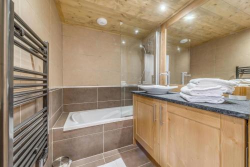 une salle de bain avec une baignoire et un lavabo dans l'établissement Résidence Les Balcons EtoilÉs - Appartement 4 au pied des pistes MAE-3263, à Champagny-en-Vanoise