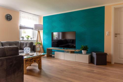 a living room with a flat screen tv on a wall at Familienapartment Vogtland in Saalig