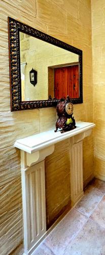a mirror on a wall above a counter with a sink at Traditional Farmhouse Central Gozo in Xagħra