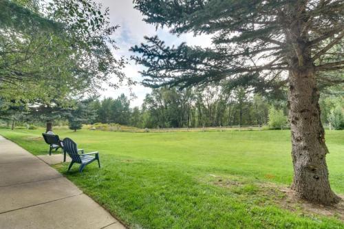 two benches sitting next to a tree in a field at River Pines C207 condo in Edwards