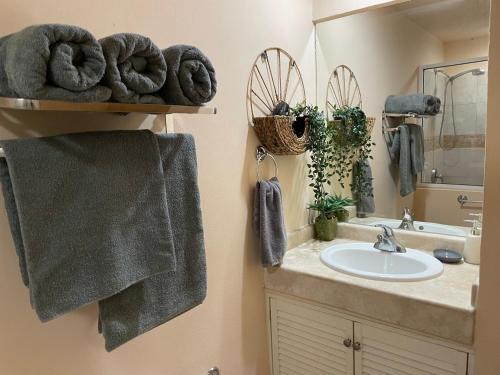 a bathroom with a sink and a mirror and towels at Corona del Mar By Rocky Host in Puerto Peñasco