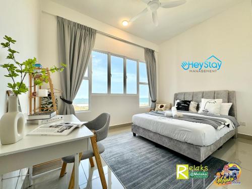 um quarto com uma cama e uma secretária em Amber Cove Impression City By Heystay Management em Malaca