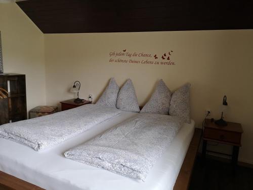 a white bed with pillows and a sign on the wall at Gasthof Schlossberg in Signau