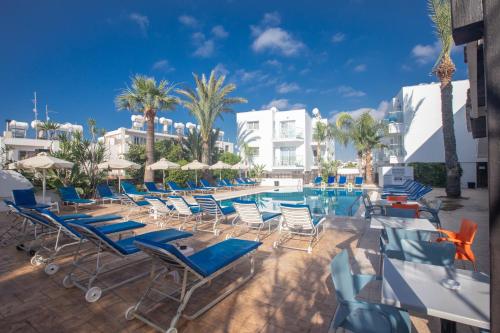 a group of chairs and a swimming pool at Pavlinia Hotel & Apartments in Ayia Napa