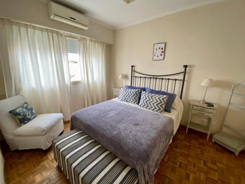 a bedroom with a bed and a chair at Recoleta Luxury Apartment in Buenos Aires