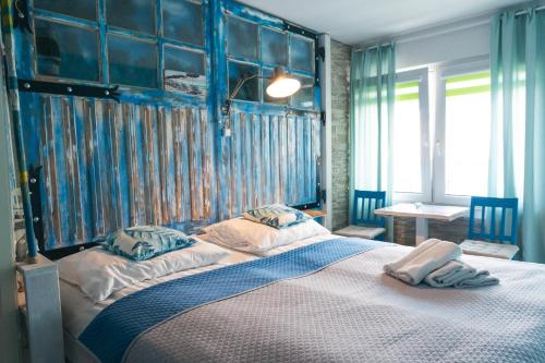 - une chambre avec un grand lit aux murs bleus dans l'établissement K 2, à Jastrzębia Góra