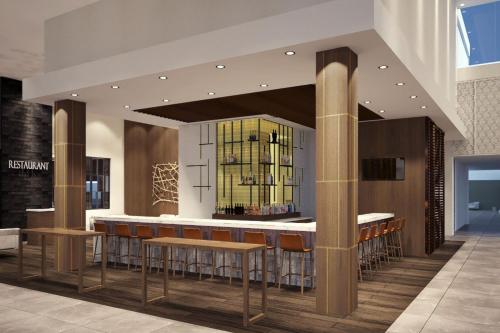 a lobby with a bar with stools and a counter at Delta Hotels by Marriott Ontario Airport in Ontario