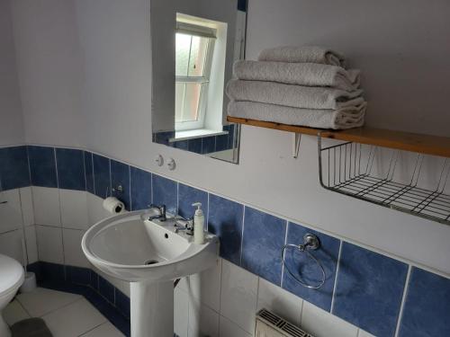 a bathroom with a sink and a mirror and towels at Sheraton Lodge Apartments t12e309 in Cork