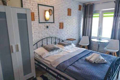 a bedroom with a bed and a brick wall at K 2 in Jastrzębia Góra