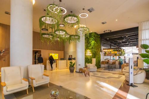 a lobby with chairs and a large chandelier at The Capital Flat Itaim Bibi in Sao Paulo