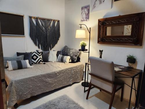 a bedroom with a bed and a desk and a mirror at Campo Paraíso Suites in Mérida