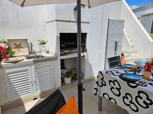 a kitchen with a table and an umbrella on a balcony at Casa Limoncello, tipica, cosy, localização top, Olhão in Olhão