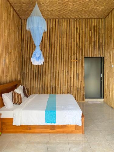 賽德曼的住宿－Lumbung ayu sari and spa，一间卧室配有一张床和一个吊灯