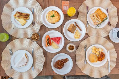 una mesa con platos de comida para el desayuno. en Hotel Areias Belas en Maragogi