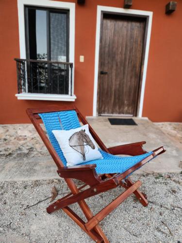 a beach chair sitting in front of a house at Campo Paraíso Suites in Mérida