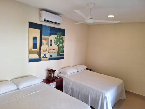 a room with two beds and a painting on the wall at Hotel La Guarida in Palma