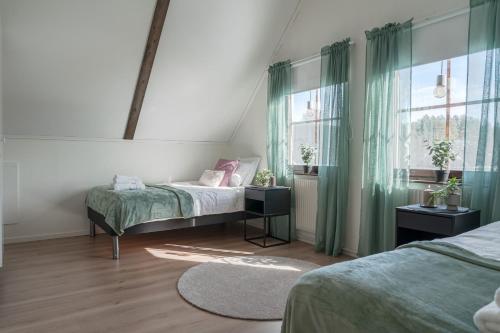 a bedroom with two beds and a window at Guestly Homes - Spacious 5BR Villa with Sauna in Södra Sunderbyn