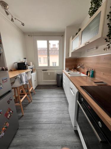 une cuisine avec des armoires blanches et un comptoir dans l'établissement Bel appartement très lumineux Hyper centre, au Mans