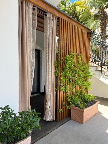 un balcón con cortinas y plantas en una casa en Apartments Residence Radovan 1, en Poreč