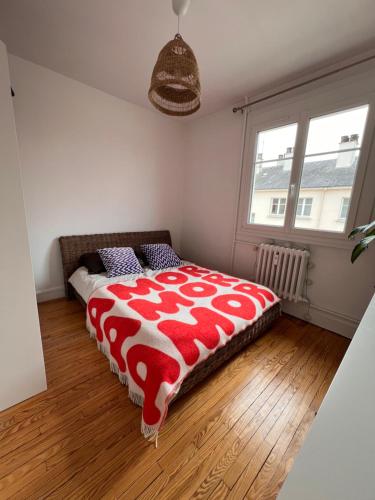 - une chambre avec un lit et une couette rouge et blanche dans l'établissement Bel appartement très lumineux Hyper centre, au Mans