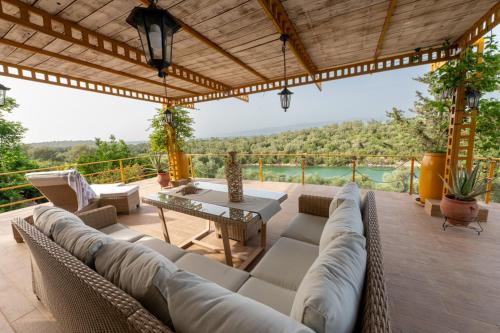 un soggiorno con divano e tavolo su un patio di Country House Hortensia a Spartos