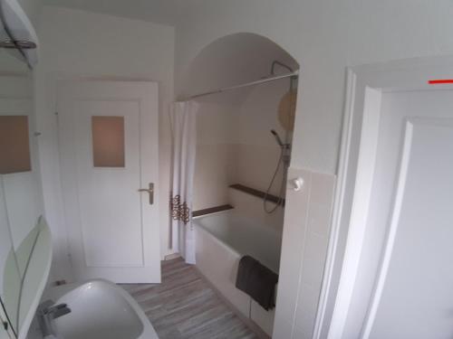 a white bathroom with a toilet and a bath tub at Ferienwohnung Albstadt Panorama in Albstadt
