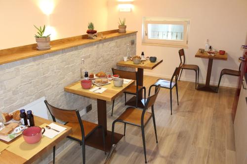 a restaurant with wooden tables and chairs and a brick wall at Bed and Breakfast Cà Tognella in Pescantina