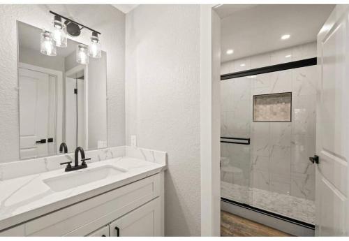 a white bathroom with a sink and a shower at Hidden Oasis Near Safari - Wineries - Lakes in Escondido
