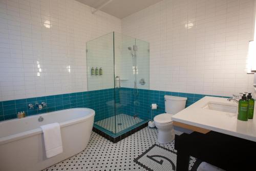 a bathroom with a tub and a shower and a toilet at Greyhound Inn in Tyler