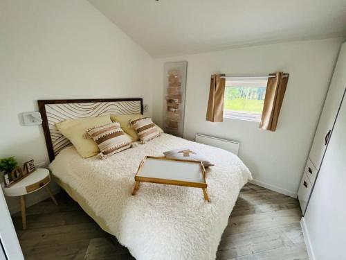 a bedroom with a bed with a table on it at Equi-Lodge Jacuzzi au coeur des chevaux & de la nature proche Disney in La Houssaye-en-Brie